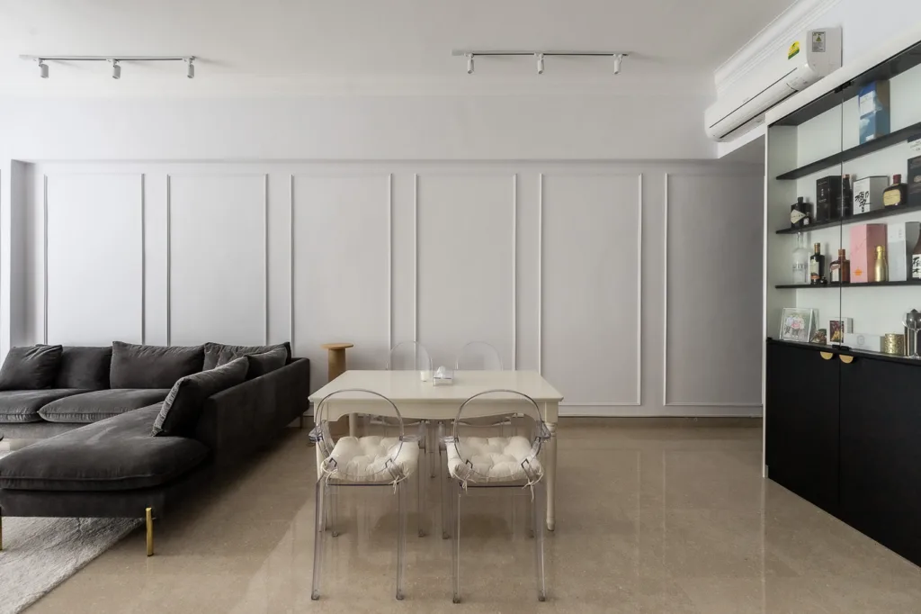 Modern living room with sofa and transparent dining chairs.