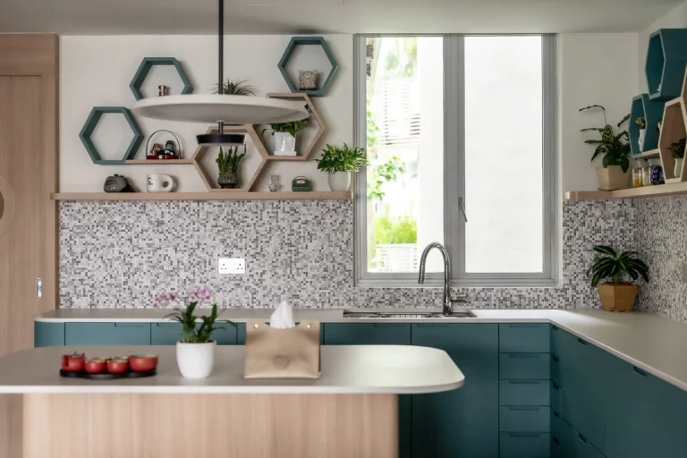 Modern kitchen interior with teal cabinets and mosaic backsplash.