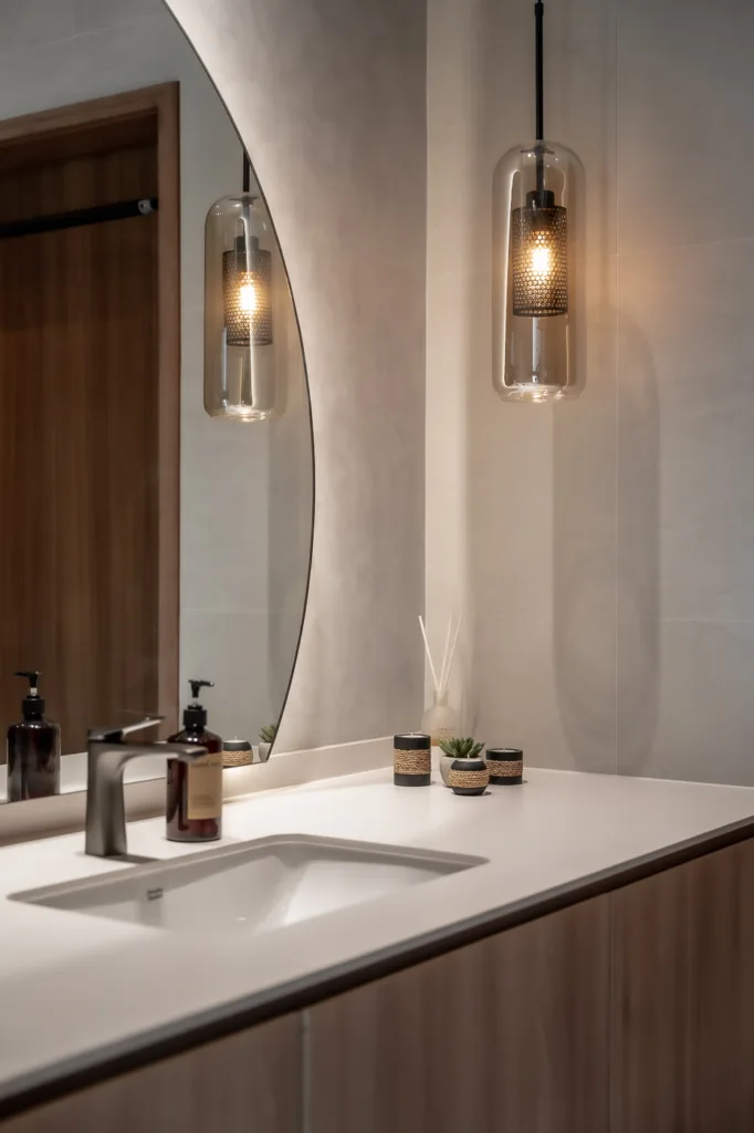 Modern bathroom with pendant lights and mirror.