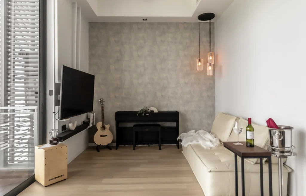 Modern living room with sofa, TV, and guitar.