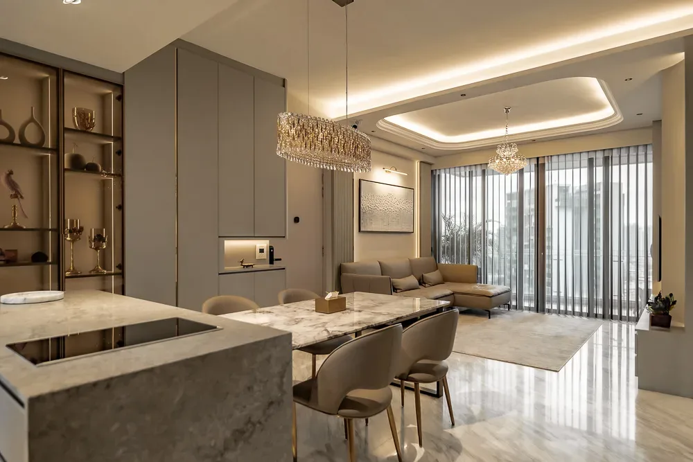 luxurious modern living and dining area with marble flooring, a crystal chandelier, grey and beige color scheme, and large windows with vertical blinds. the modern dining table has beige chairs, and the sofa is in the lounge area.