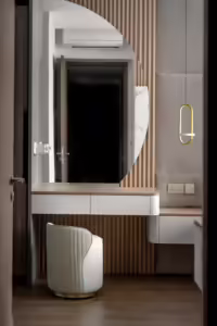 Modern vanity with curved mirror and upholstered stool at 24 Sumang Walk.