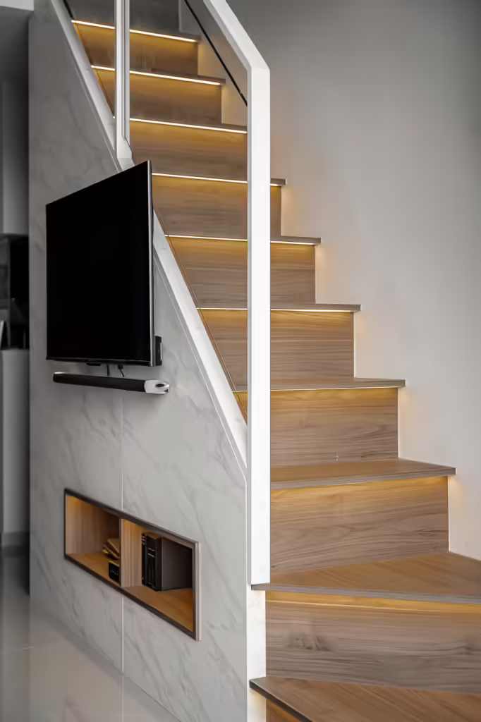 Modern loft staircase with integrated TV and built-in shelving at 32 Sumang Walk.