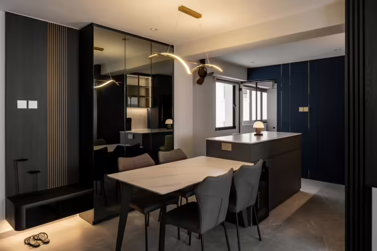 Modern dining area with dark cabinetry and marble table in 704 Tampines apartment.