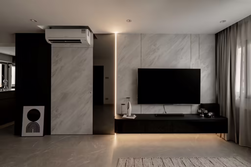 Modern living room interior design in a 704 Tampines HDB flat, featuring a sleek black media console and marble wall.