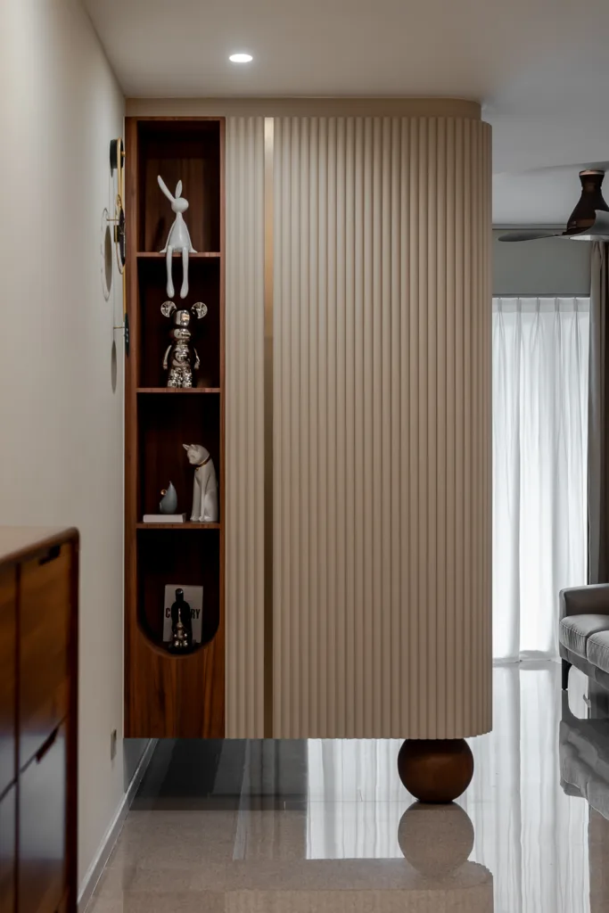 Modern hallway with minimalist shelving, decorative objects, and curved wall paneling. — at 812 Bedok Reservoir Road, a condo interior by IS Design Studio