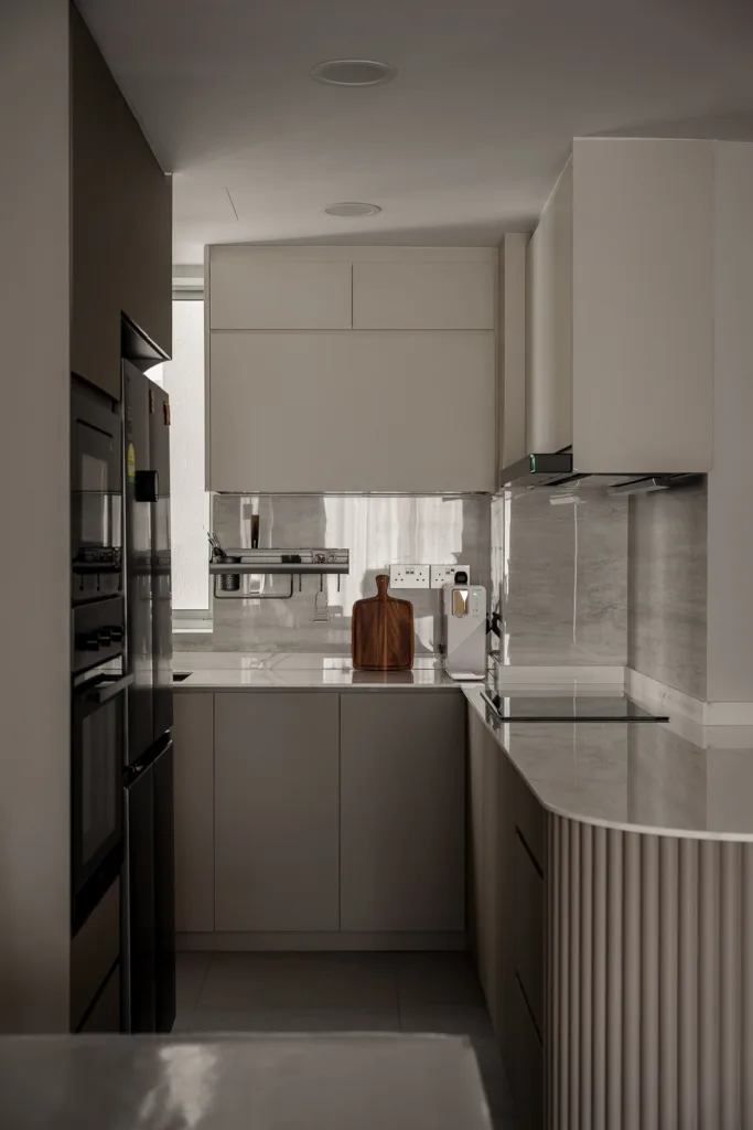 Modern minimalist kitchen with marble countertops and neutral-toned cabinetry. — at 812 Bedok Reservoir Road, a condo interior by IS Design Studio
