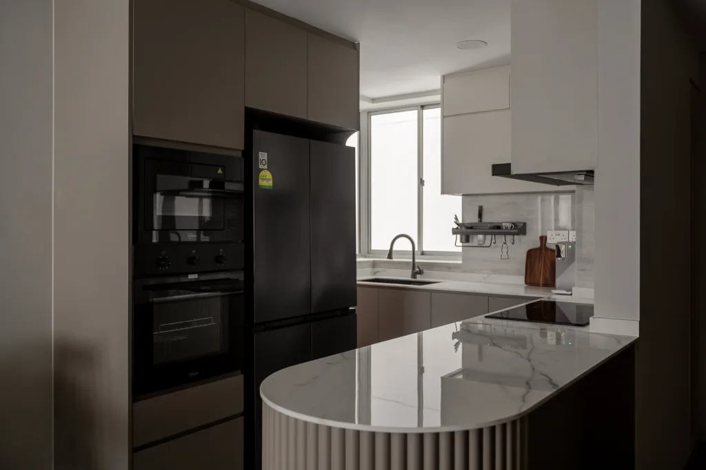 Modern kitchen with marble island, dark cabinetry, and built-in appliances. — at 812 Bedok Reservoir Road, a condo interior by IS Design Studio