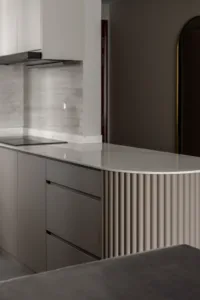 Modern kitchen island with fluted cabinetry and marble countertop