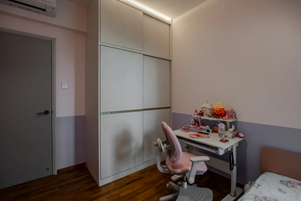 Girl's bedroom with built-in wardrobe, desk, and chair.