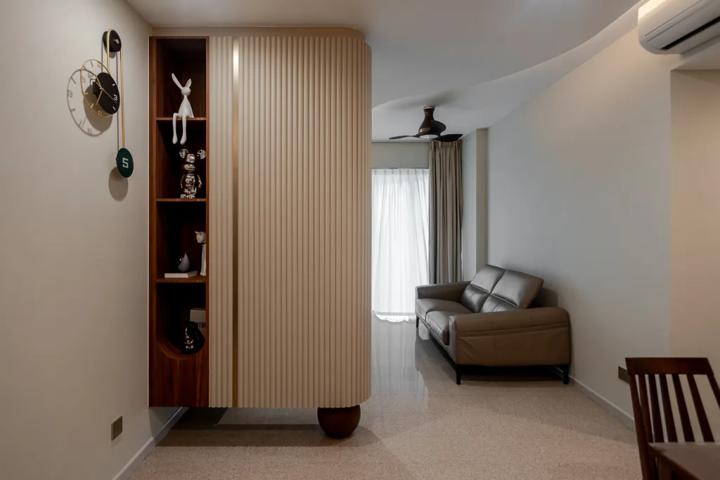 Modern living room with beige fluted wall partition, leather sofa, and decorative shelving. — at 812 Bedok Reservoir Road, a condo interior by IS Design Studio