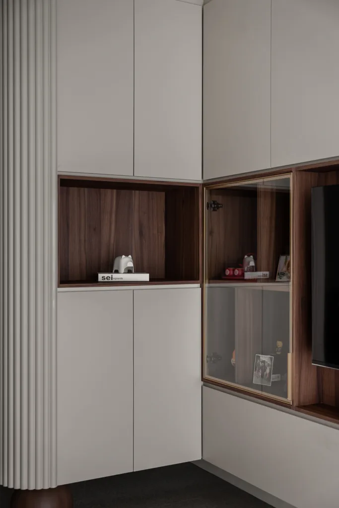Modern minimalist corner cabinet with walnut shelves and glass display case. Features a Sei design book. — at 812 Bedok Reservoir Road, a condo interior by IS Design Studio