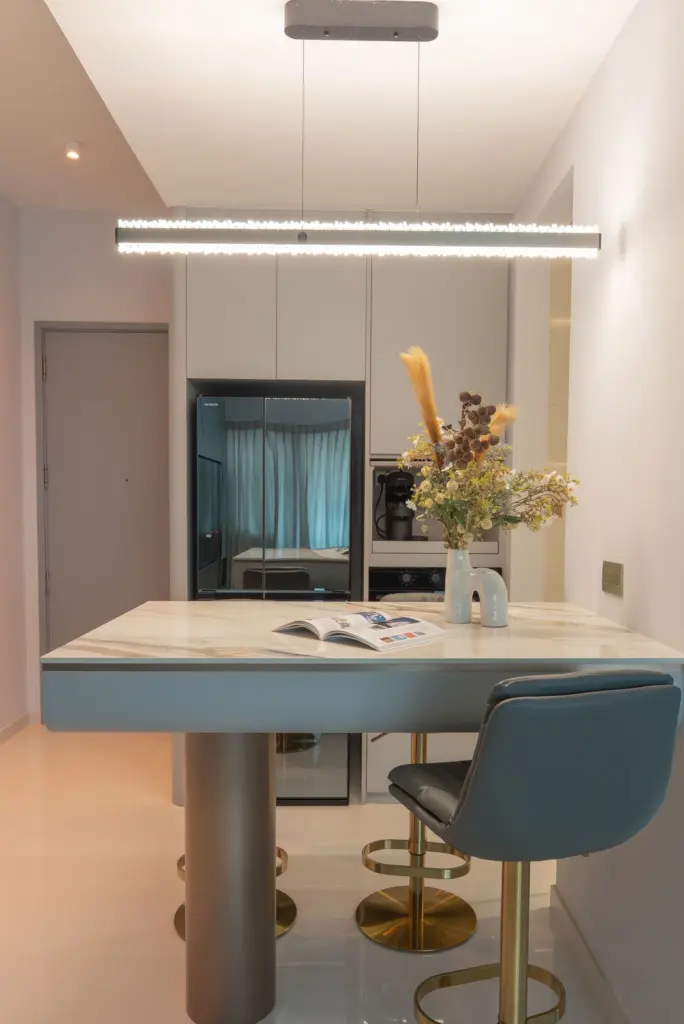 Modern kitchen with table and decorative flowers. — at Soleil @ Sinaran, a condo interior by IS Design Studio