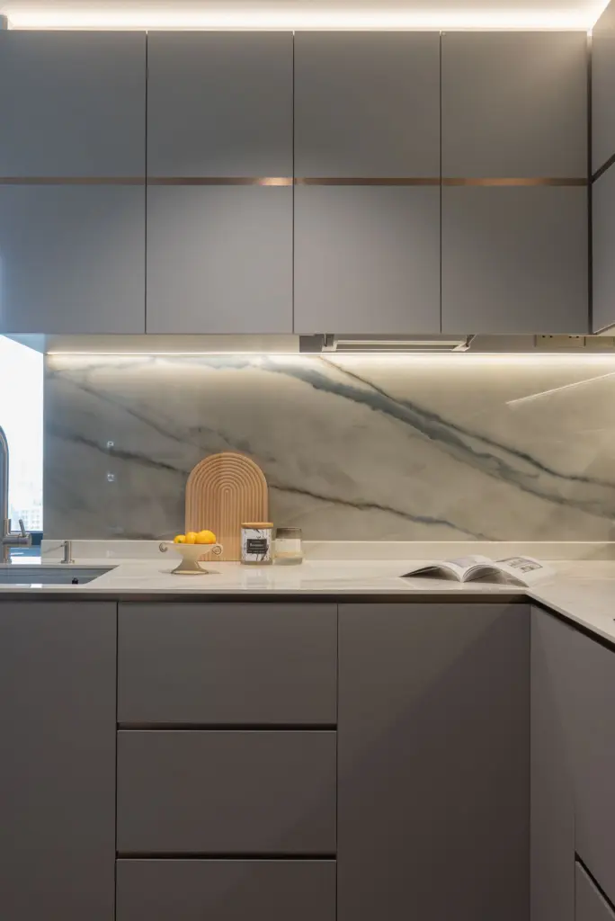 Modern kitchen with marble backsplash and decor — at Soleil @ Sinaran, a condo interior by IS Design Studio