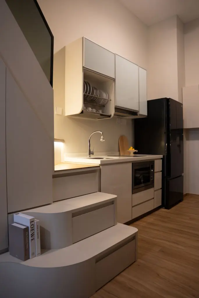 Modern kitchen with sleek appliances and wooden flooring. — at Suites @ East Coast, a loft interior by IS Design Studio