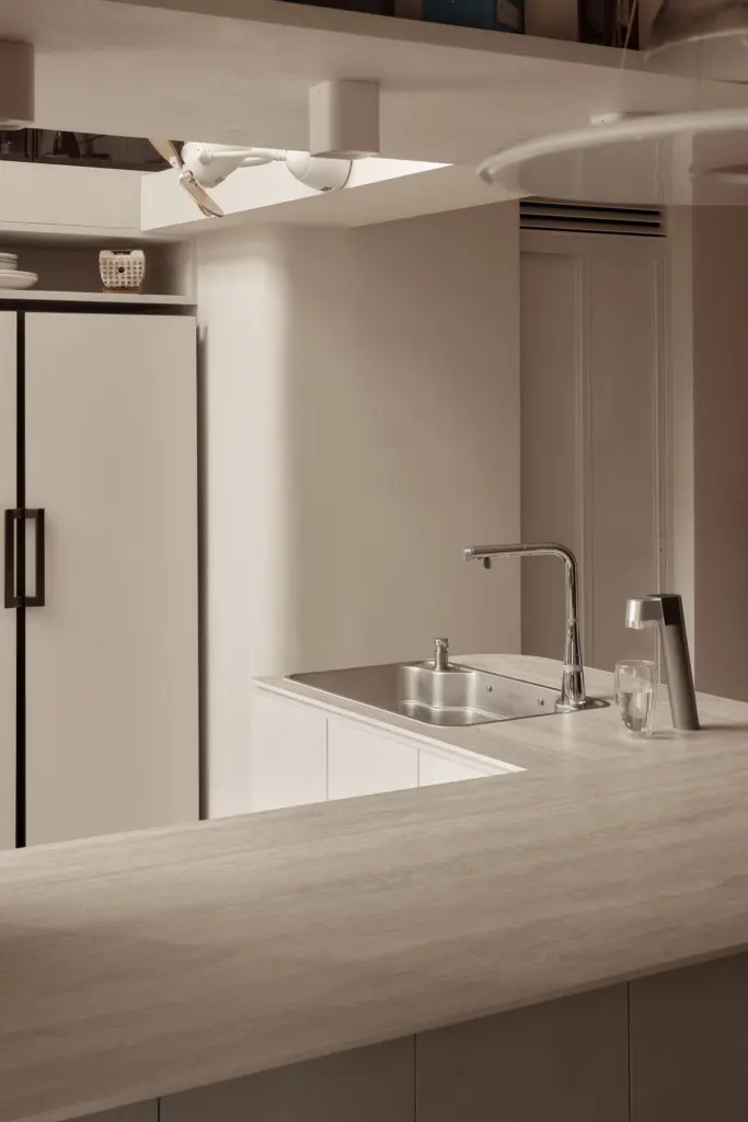 Modern kitchen with sink and light fixtures — at Kim Keat Avenue, an HDB executive maisonette by IS Design Studio