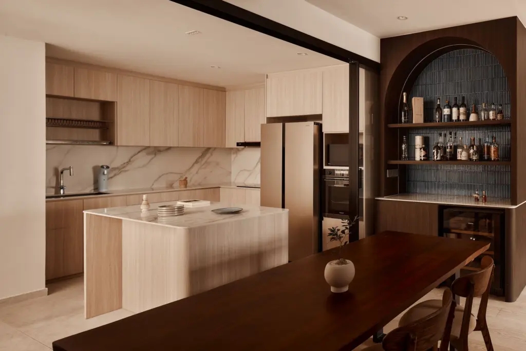 Modern kitchen with wooden cabinets and bar area.