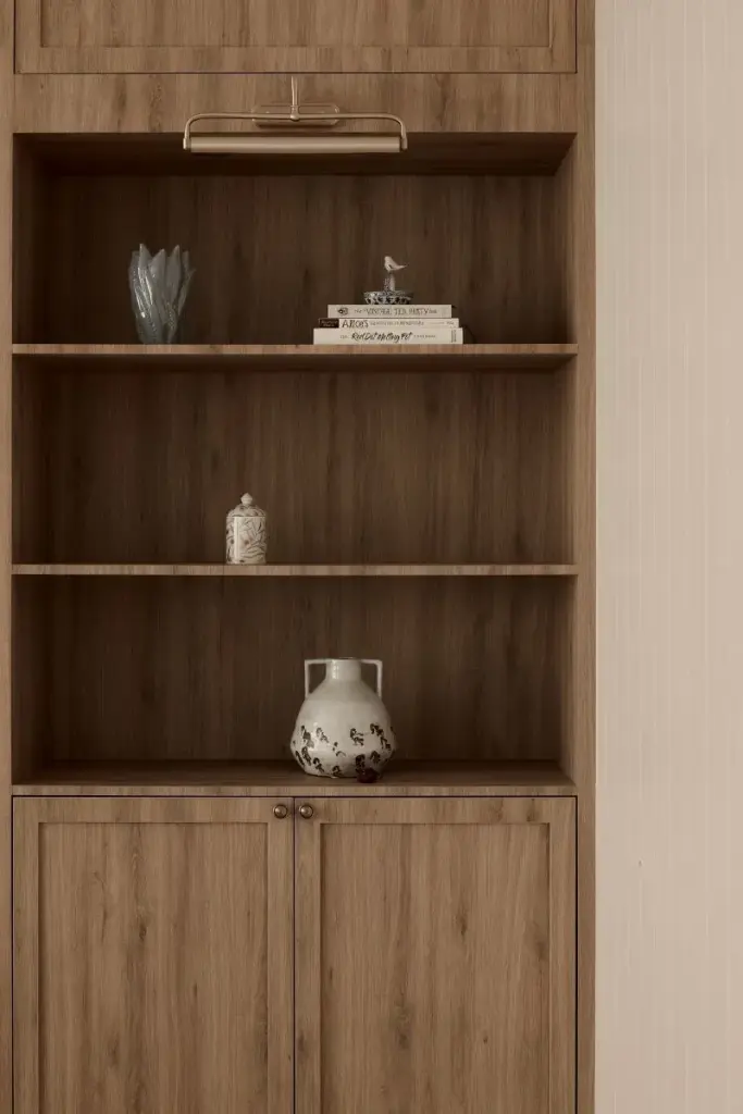 Wooden bookshelf with decorative books and pottery — at Eastwood, a modern luxury condo by IS Design Studio