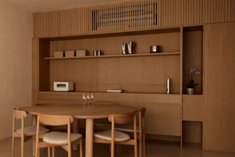 Minimalist wooden dining room with table and chairs.