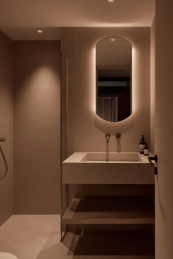 Minimalist bathroom with illuminated mirror and sink.